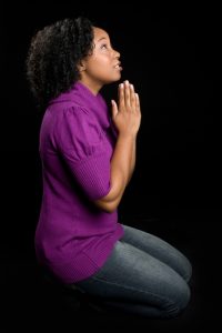 Black woman on knees praying
