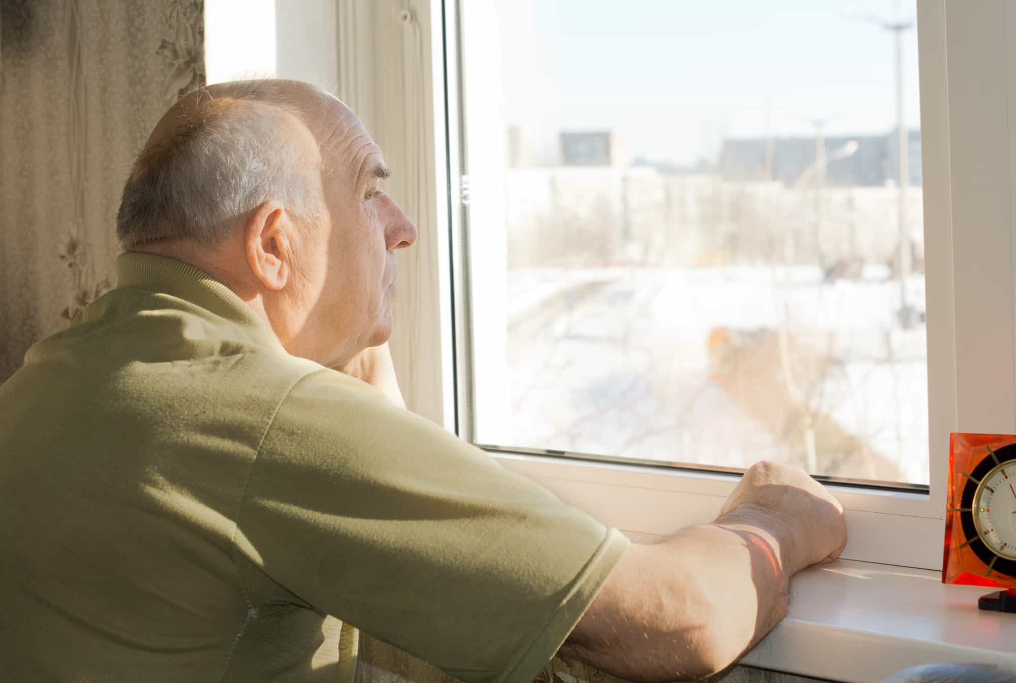 В скромно обставленном кабинете сидел пожилой человек. Старик у окна. Пожилые люди у окна. Окна для пенсионеров. Дед в окне.